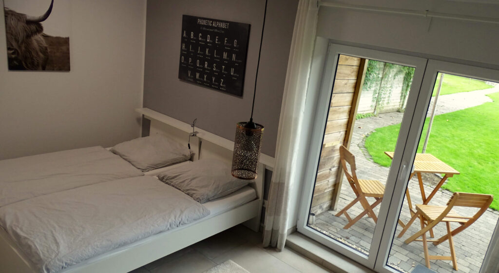Blick auf das Doppelbett und die Terrasse